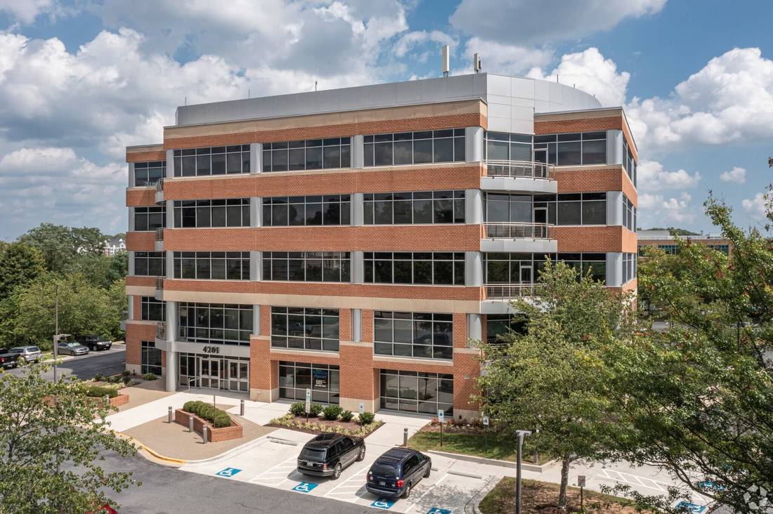 4201 Mitchellville Road, a five-story red-brick and glass Class A office building on a sunny day