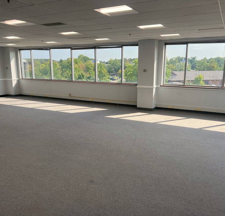 Bright suite interior with large windows at 4201 Mitchellville Road